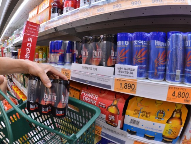 A consumer buys an energy drink at a supermarket in Seoul on Thursdday. (Lee Sang-sub/The Kore Herald)