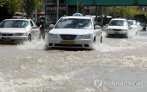 Cars wedging their way through waterlogged streets in Mokpo, South Joella Province (Yonhap News)