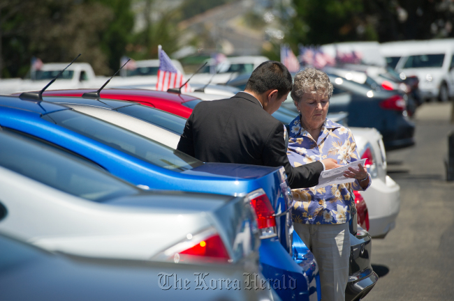 A customer listens to a car salesman at a Ford Motor dealership in Colma, California.   Bloomberg
