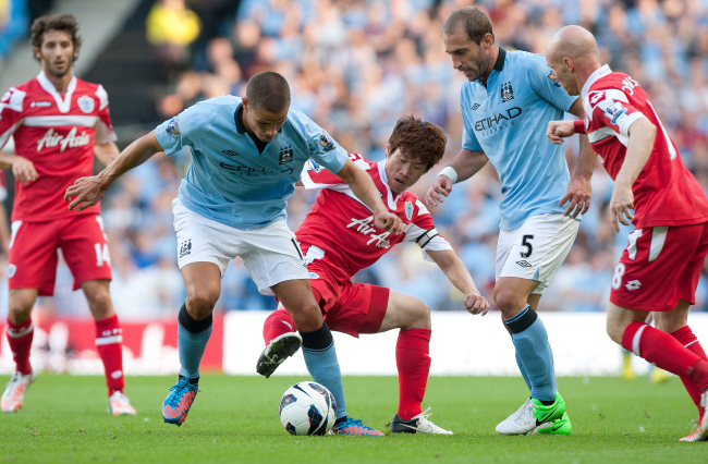 Park Ji-sung (center) challenges Jack Rodwell of Manchester City at the Etihad Stadium in Manchester, England, Saturday.    PENTA PRESS-Yonhap News