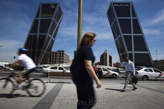 Pedestrians pass the Kio towers, the headquarters of Bankia SA in Madrid.   Bloomberg