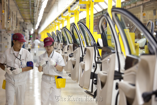 Employees at the Fiat SpA and Guangzhou Automobile Group Co. manufacturing plant walk past door assemblies for Viaggio vehicles in Changsha, Hunan Province, China.   Bloomberg