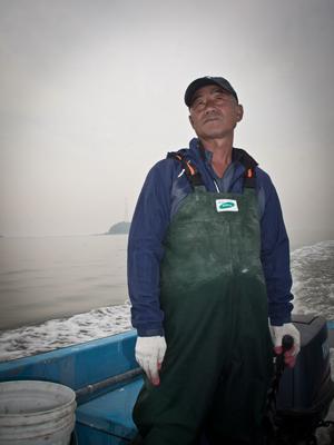 Kim Seon-man looks out onto the ocean from his boat. (Yonhap News)