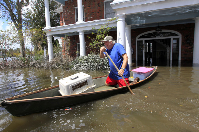 Don Duplantier paddles a pirogue from his flooded home as floodwaters from Hurricane Isaac recede in Braithwaite, Louisiana, Sunday.   AP-Yonhap News