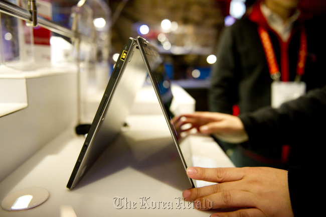 A Lenovo Group Ltd. Ideapad Yoga, a touchscreen clamshell computer which flips completely over on itself and can be used like a tablet, sits on display during the 2012 International Consumer Electronics Show in Las Vegas.   Bloomberg