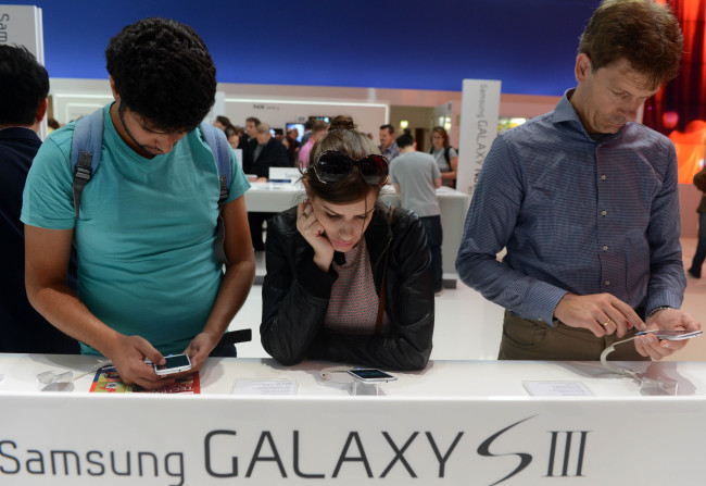 Visitors try out the Samsung Galaxy S3 smartphones at the Samsung pavilion at the IFA consumer electronics fair in Berlin,on Friday.   Xinhua-Yonhap News