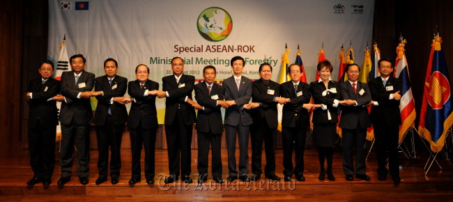 Korea Forest Service Minister Lee Don-koo (seventh from left) joins hands with chief delegates from ASEAN member states at the end of the Special ASEAN-Korea Ministerial Meeting on Forestry in Seoul last week.   KFS