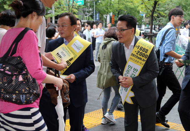 Democratic United Party Chairman Rep. Lee Hae-chan and floor leader Rep. Park Jie-won hand out leaflets promoting the party’s half-tuition policy and calling for citizens’ participation in its presidential primary on the street in Seoul. Despite such efforts, its presidential race is failing to get public attention.   Yonhap News