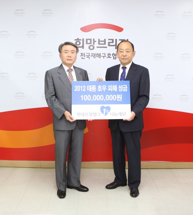 김창기(왼쪽) 현대오일뱅크 1%나눔재단 이사장이 최학래 희망브리지 전국재해구호협회장에게 태풍 호우 피해성금 1억원을 전달하고 있다.