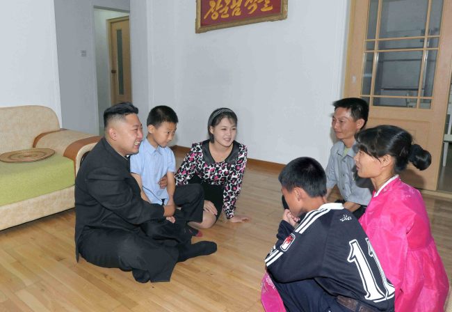 Kim Jong-un (left) and his wife Ri Sol-ju (third from left) visit a home of a working-class family in a new town district in Pyongyang in this undated image disclosed by the North’s official Korean Central News Agency on Wednesday.   Yonhap News