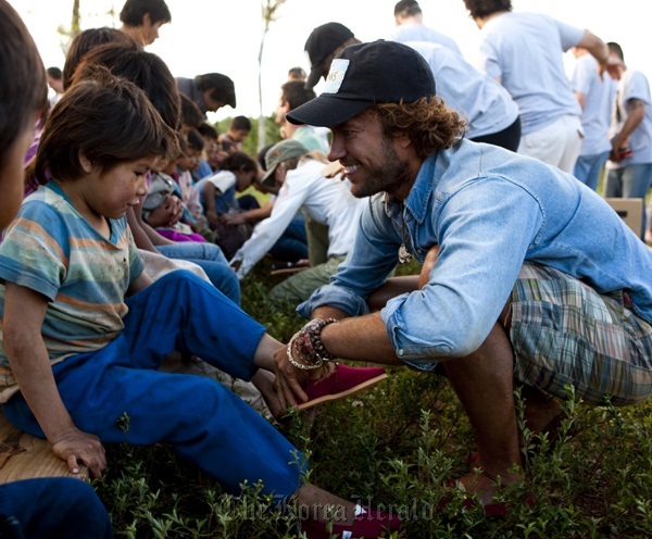 Blake Mycoskie (right), founder and chief shoe giver of Toms Shoes,
delivers shoes to kids in Argentina in 2010.   Toms Shoes
