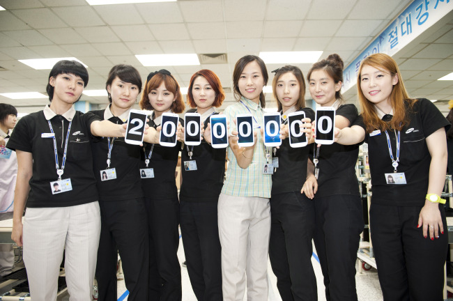 Samsung employees hold up Galaxy S3 smartphones displaying “20,000,000” following the newest model’s record sales worldwide.   Samsung Electronics