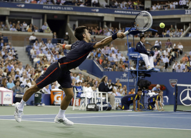 Novak Djokovic returns a shot against Juan Martin del Potro on Thursday.   AP-Yonhap News