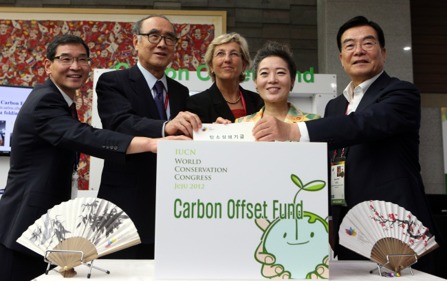 Participants of the 2012 IUCN World Conservation Congress pose for photos after making donations to a carbon offseting program designed to reduce carbon dioxide produced during their travel to the conference. From left: Yoon Seung-joon, president of Korea Environmental Technology & Industry Institute; Lee Hong-koo, chairman of the Korean Organizing Committee of the 2012 WCC; Julia Marton-Lefevre, IUCN secretary-general; Yoo Young-sook, environmental minister of Korea; and Woo Keun-min, governor of Jeju Self-Governing Province.   Yonhap News