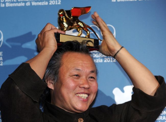 South Korean film director Kim Ki-Duk holds the Golden Lion for best movie on his head during a photocall following the award ceremony of the 69th Venice Film Festival on Saturday at Venice Lido. (AFP-Yonhpa News)