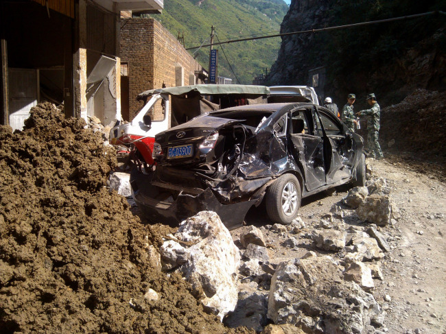 In this photo provided by China’s Xinhua News Agency, damaged cars are seen in Luozehe town, Yiliang County, southwest China’s Yunnan province, Friday.   AP-Yonhap News
