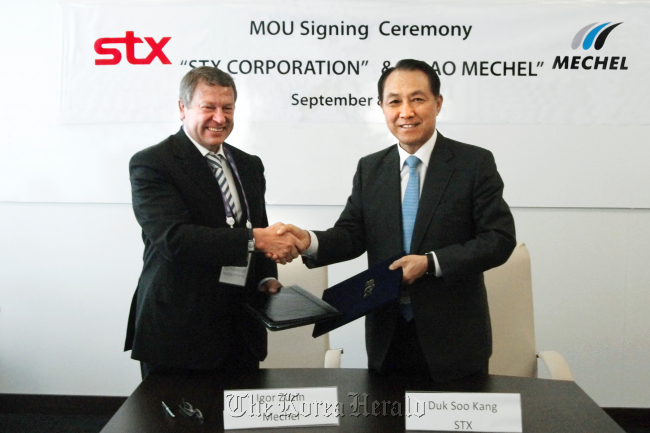 STX Group chairman Kang Duk-soo (right) and Mechel CEO Igor Zyuzin shake hands after signing a memorandum of understanding in Vladivostok, Russia, Saturday.   STX Group
STX Group chairman Kang Duk-soo (right) and Mechel CEO Igor Zyuzin shake hands after signing a memorandum of understanding in Vladivostok, Russia, Saturday.   STX Group
