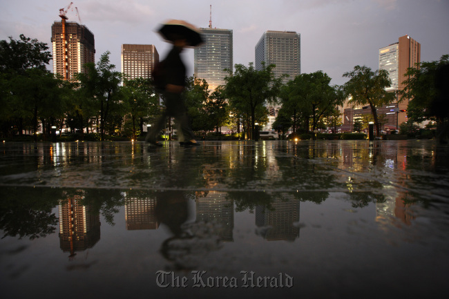 A pedestrian walks past commercial buildings in Osaka. Bloomberg