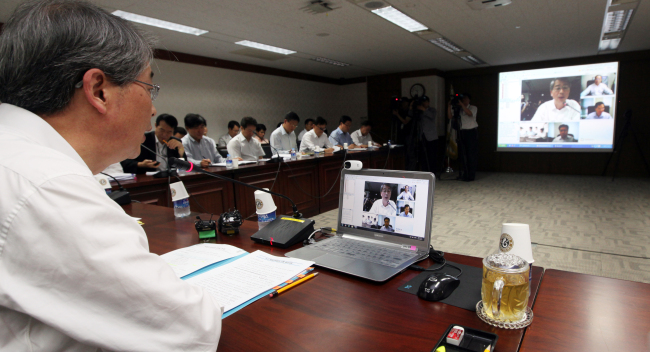 Officials of the Prime Minister’s Offices in Seoul and Sejong City hold a video conference Wednesday.   Yonhap News