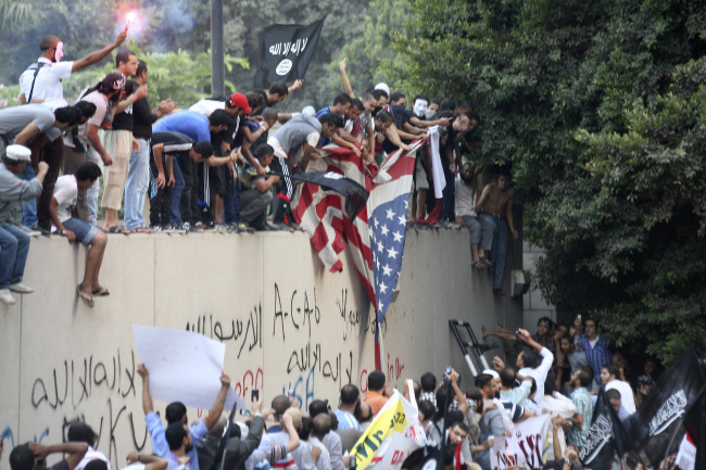 Protesters destroy an American flag pulled down from the U.S. Embassy in Cairo on Tuesday.   AP-Yonhap News