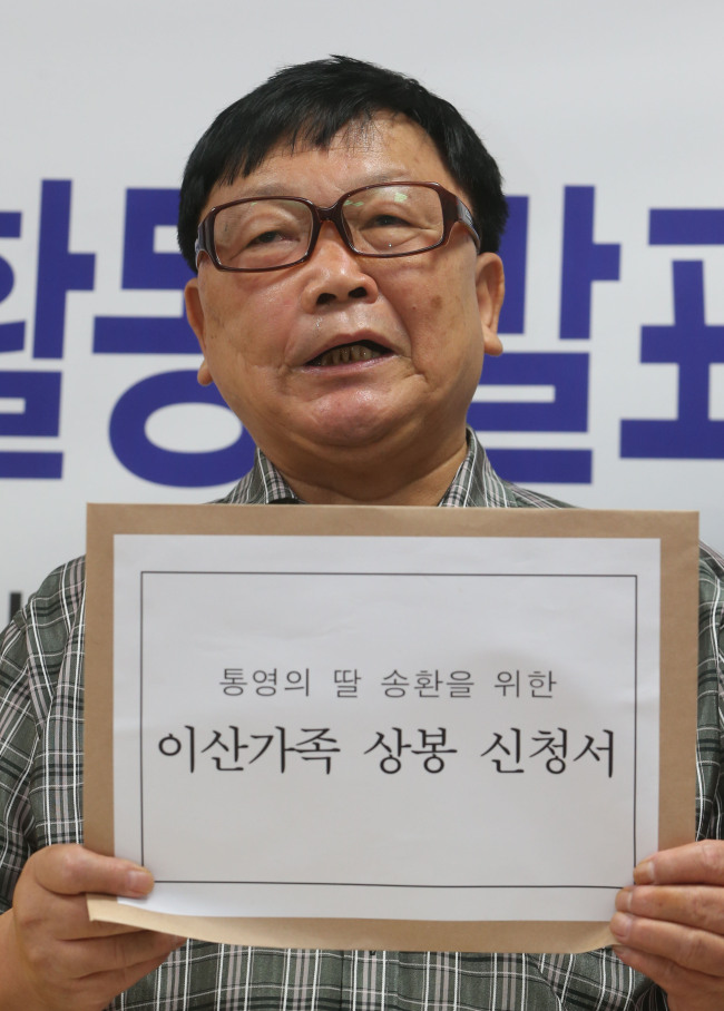 <YONHAP PHOTO-0803> 이산가족 찾기 신청서 든 오길남 씨 (서울=연합뉴스) 임헌정 기자 = '통영의 딸' 신숙자 씨의 남편 오길남 씨가 4일 서울 중구 남산동3가 대한적십자사에서 이산가족 찾기 신청서를 제출하기에 앞서 기자회견을 하고 있다. 독일 체류 중 가족과 함께 1985년 밀입북했다가 혼자 탈출한 오씨는 이날 북한에 있는 두 딸을 만나기 위해 한적에 이산가족 찾기를 신청했다. 2012.9.4 kane@yna.co.kr/2012-09-04 13:13:19/ <저작권자 ⓒ 1980-2012 ㈜연합뉴스. 무단 전재 재배포 금지.>
Oh Kil-nam, a retired economist, shows his application for a reunion with his two daughters detained in North Korea at the Korean Red Cross office in Seoul on Sept. 4.   Yonhap News