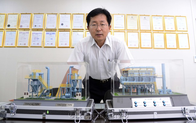 Jang Du-hun, CEO of J-E Tech, poses with models of dust collectors at his office in Ansan, Gyeonggi Province, during a recent interview.
Park Hae-mook/The Korea Herald
