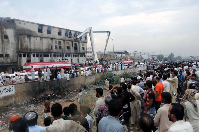 Pakistani firefighters conduct rescue operation at the garments factory in southern Pakistani port city of Karachi on Wednesday.   Xinhua-Yonhap News
