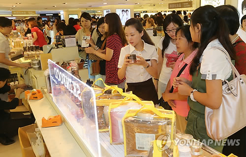 Customers gathers at the cosmetics counter in a duty-free shop located in downtown Seoul. (Yonhap News)