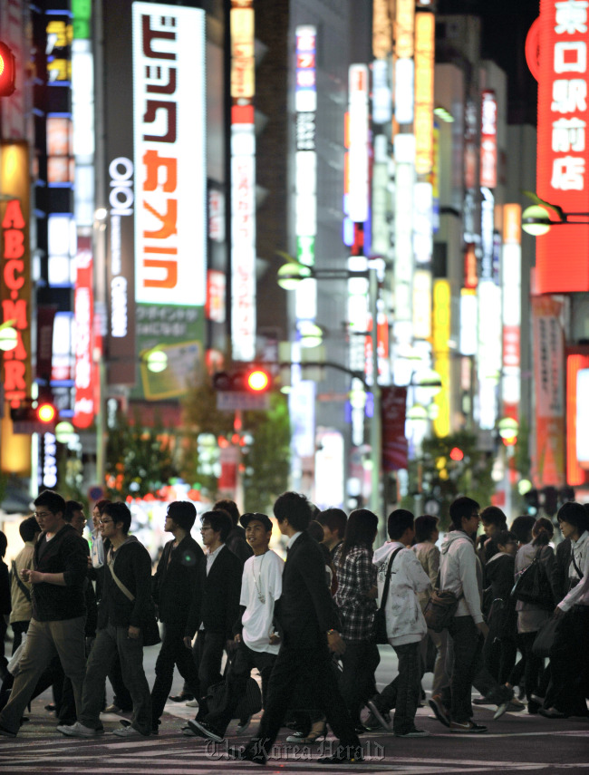 Pedestrians cross an intersection in the Shinjuku district of Tokyo.    Bloomberg
Pedestrians cross an intersection in the Shinjuku district of Tokyo.    Bloomberg