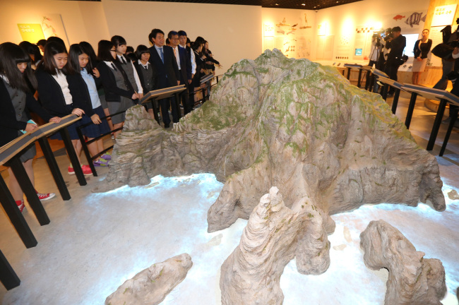 Education, Science and Technology Minister Lee Ju-ho (seventh from left) and visitors view a Dokdo miniature model at Dokdo Museum in downtown Seoul on Friday.   Yonhap News