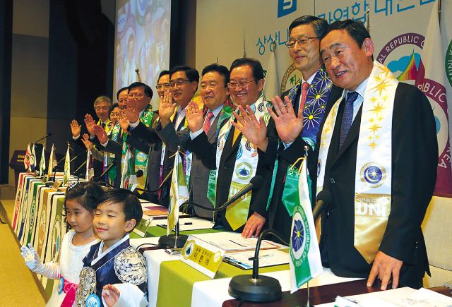 CEO of the Republic of Naminara Kang Woo-hyon (right) and mayors of provincial governments pose for a photo at the launch of the United Nations of Imagination, a travel consortium that combines diverse travel programs of the different provinces in Korea in Seoul  on Tuesday.   (Yonhap News)