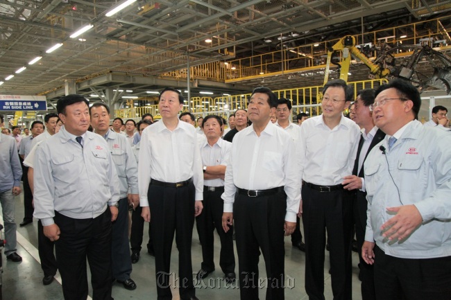 China’s senior political adviser Jia Qinglin (third from left, front row) looks at assembly lines of Dongfeng Yueda Kia, the Chinese operation of Kia Motors, Friday.   Kia Motors