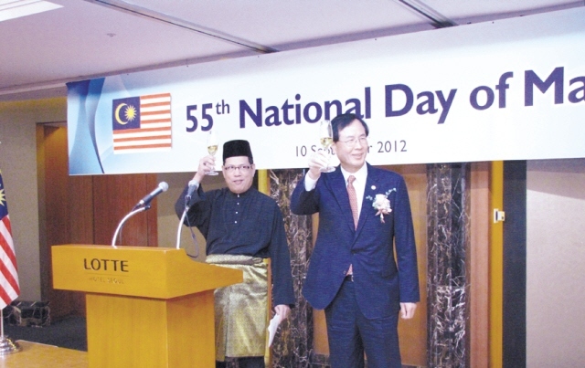 Malaysian Ambassador to Korea Dato’ Ramlan bin Ibrahim (left) and Noh Dae-lae, commissioner of Korea’s state-run Defense Acquisition Program Administration, raise their glasses in a toast at Malaysia’s 55th National Day reception at Lotte Hotel in Seoul on Monday. (Philip Iglauer/The Korea Herald)
