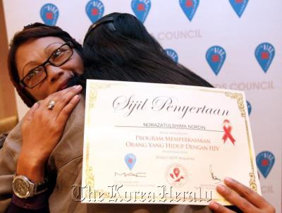 Norazatulshima Nordin hugs a fellow participant after completing a Malaysian AIDS Council program on living with HIV/AIDS.   The Star