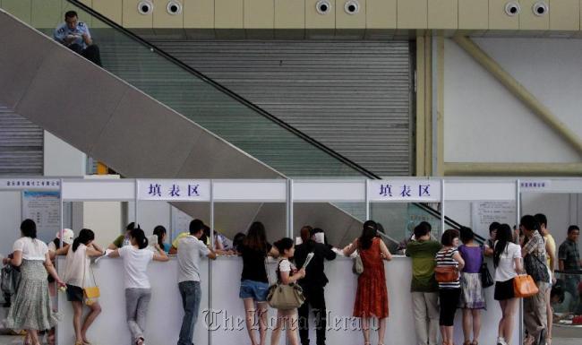 Job seekers write application forms during a job fair in Lianyungang, east China’s Jiangsu Province.   Xinhua-Yonhap News