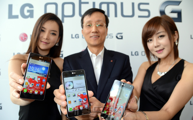 Park Jong-seok (center), mobile chief at LG Electronics, and models pose with LG’s new flagship smartphone Optimus G  at a product launch in Seoul on Tuesday.   Ahn Hoon/The Korea Herald