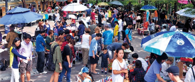 Visitors walk around to the various vendors at the Hongdae Art Free Market, western Seoul, last Saturday. (Lee Sang-sub/The Korea Herald)