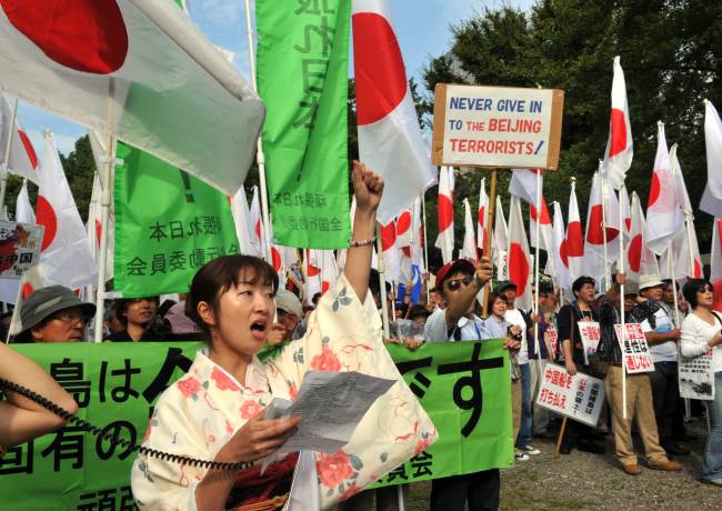 Right wing acrivists hold national flags and placards to protest against China in Tokyo on Saturday.   AFP-Yonhap News