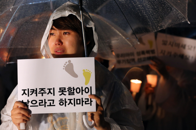 A woman participates in a candlelit rally against sex crimes, in Seoul on Sept. 4.   Yonhap News