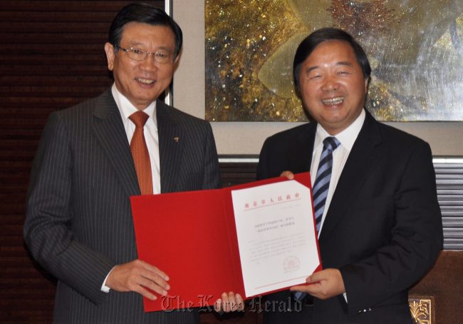 Kumho Asia Group chairman Park Sam-koo (left) poses with a Nanjing official after receiving the certificate of honorary citizen of the Chinese city of Nanjing on Monday.   Kumho Asiana
