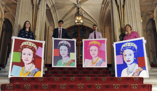 From left: Exhibition curator Lauren Porte, Royal Collection staff Allan Chinn, Martin Clayton, and Kate Stone stand with four Andy Warhol portraits of Queen Elizabeth II in Windsor Castle, Windsor, England, on Monday.   AP-Yonhap News