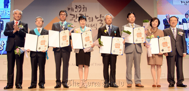 Culture Minister Choe Kwang-shik (left), Lotte Hotel CEO Song Yong-dok (second from left) and other recipients of the Orders of Industrial Service Merit, given by the Culture Ministry, pose for a photo at the Tourism Day ceremony on Thursday in Seoul.   Ahn Hoon/The Korea Herald