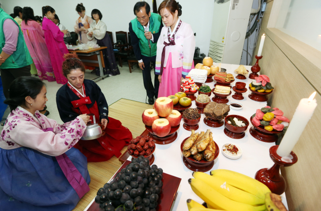 Migrant women participate in a traditional memorial service for honoring family ancestors at a class held in Neung-dong, Seoul, Monday.   Yonhap News