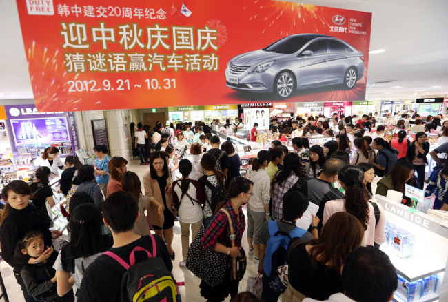 Visitors shop at a duty free shop in Lotte Department Store in Sogong-dong, Seoul, on Tuesday. A large number of Chinese tourists are expected in Korea as China began a long holiday last week.   Yonhap News