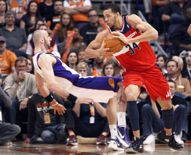 This file photo shows Phoenix Suns center Marcin Gortat trying to take a charge against Washington Wizards center JaVale McGee.   AP-Yonhap News