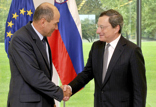 Slovenia’s Prime Minister Janez Jansa (left) shakes hands with ECB chief Mario Draghi on Thursday.   AP-Yonhap News