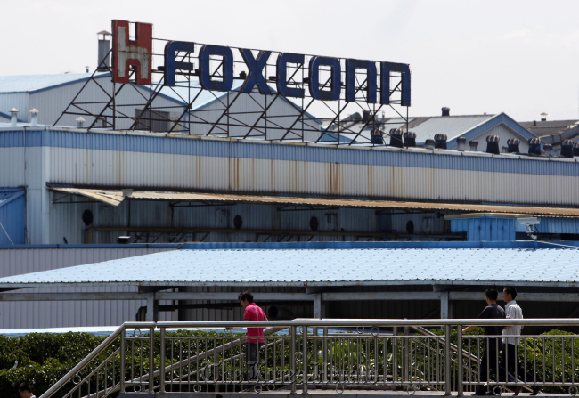 Workers walk outside a Foxconn plant in Shenzhen, Guangdong province, China.   Bloomberg