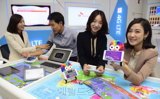 SK Telecom T.um staff members demonstrate the latest LTE technologies at the renovated T.um LTE zone at its Seoul headquarters on Monday.   Park Hae-mook/The Korea Herald