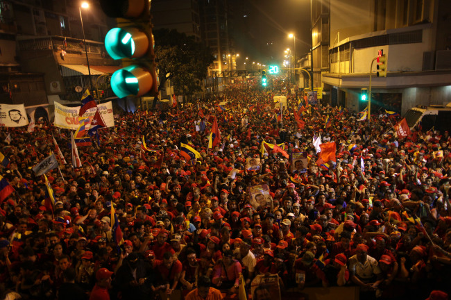 Supporters of President Hugo Chavez gather next to the Miraflores presidential palace as they celebrate in Caracas, Venezuela, Sunday.   AP-Yonhap News