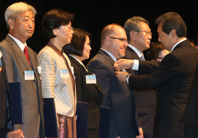 Professor S. Goksel Turkozu (fourth from left) from the University of Erciyes, Turkey, along with nine others, receives a Presidential Citation from Minister of Public Administration and Security Maeng Hyung-kyu on Tuesday.   Yohhap News